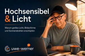 Hochsensibel & Licht: Warum Helligkeit erschöpft. Eine Person sitzt an einem Schreibtisch vor einem Laptop in einem warmbeleuchteten, ruhigen Zimmer am Abend. Helles Licht kommt nur von der Schreibtischlampe, der Raum dahinter liegt im Halbdunkel.